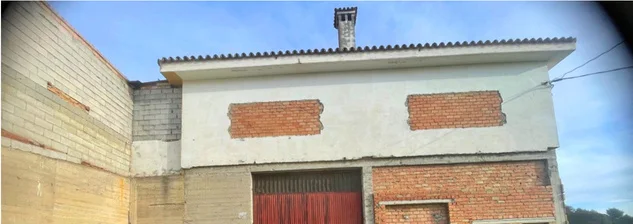 Side of the building with a painted gable and brick panels