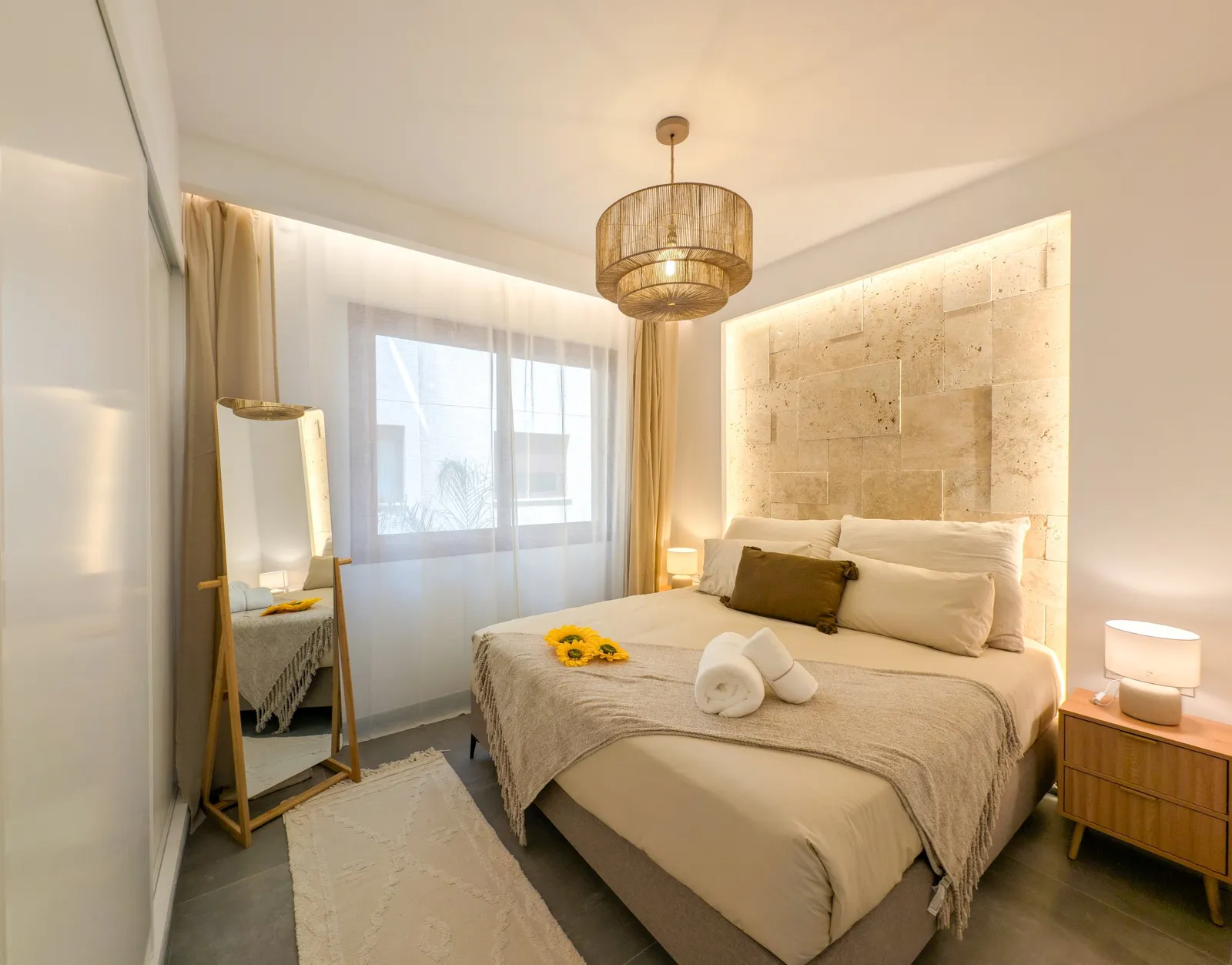 A bedroom with a stone headboard wall