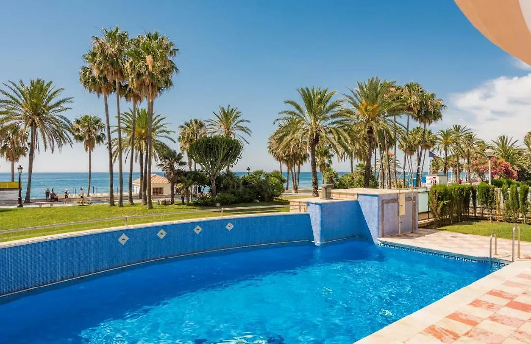 Communal pool with palms and the sea