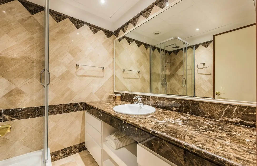 Bathroom with marble counter and glass shower