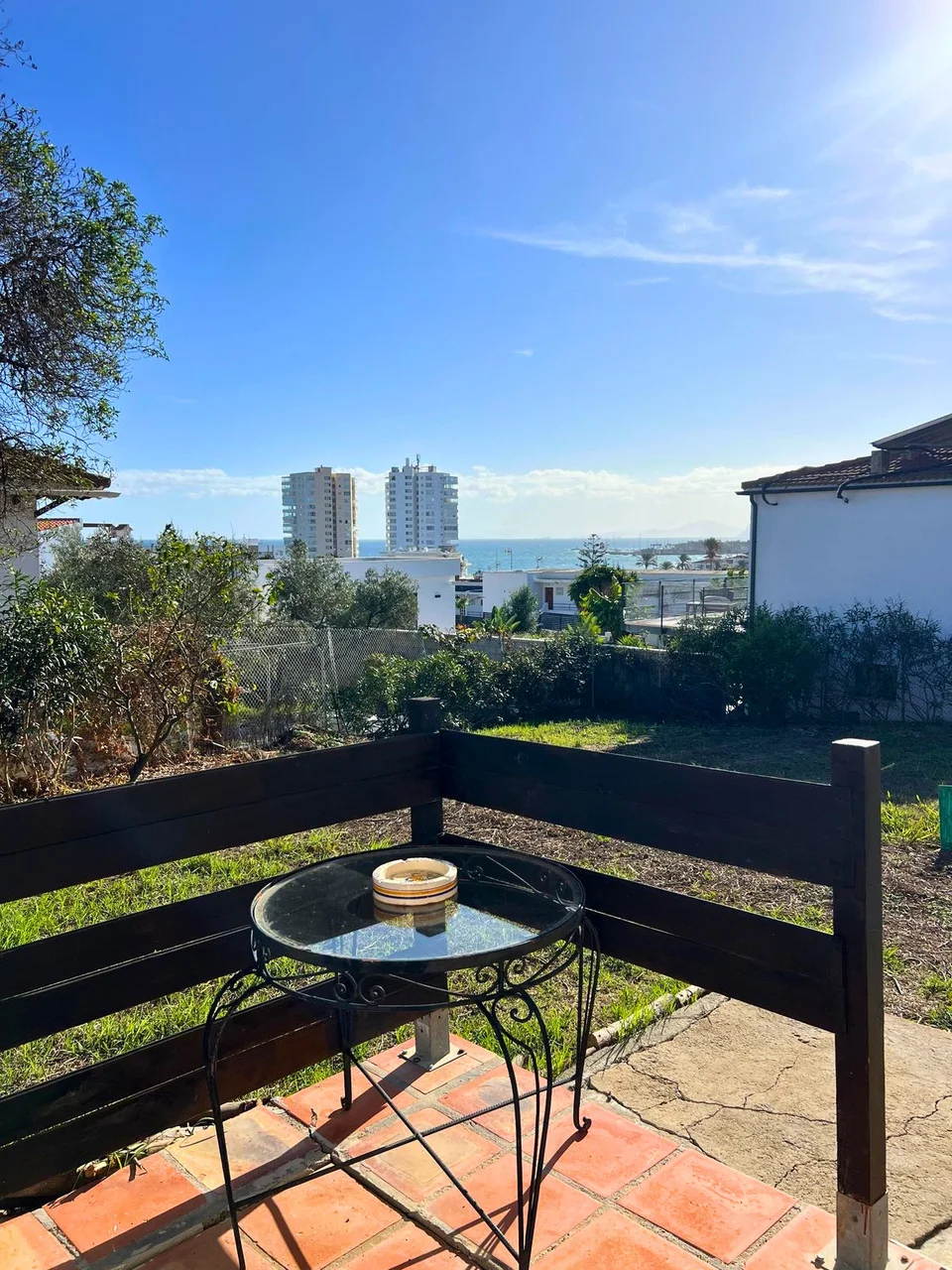 Terrace and lawn with the sea beyond the village